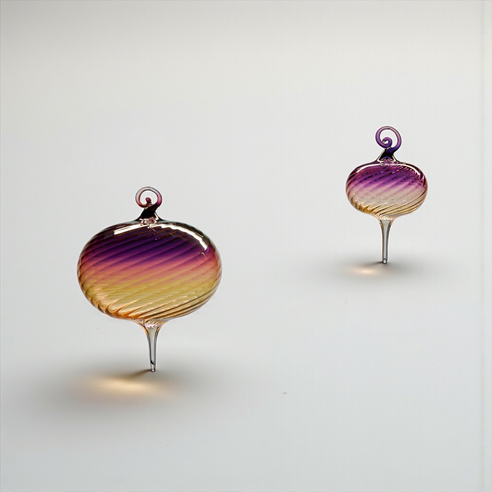 Pair of colorful glass ornaments on a white background
