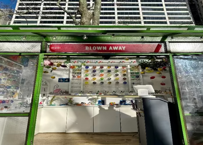 Storefront with 'Blown Away' sign and various items on display
