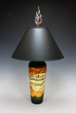 Decorative lamp with a black shade and multicolored base on a gradient background