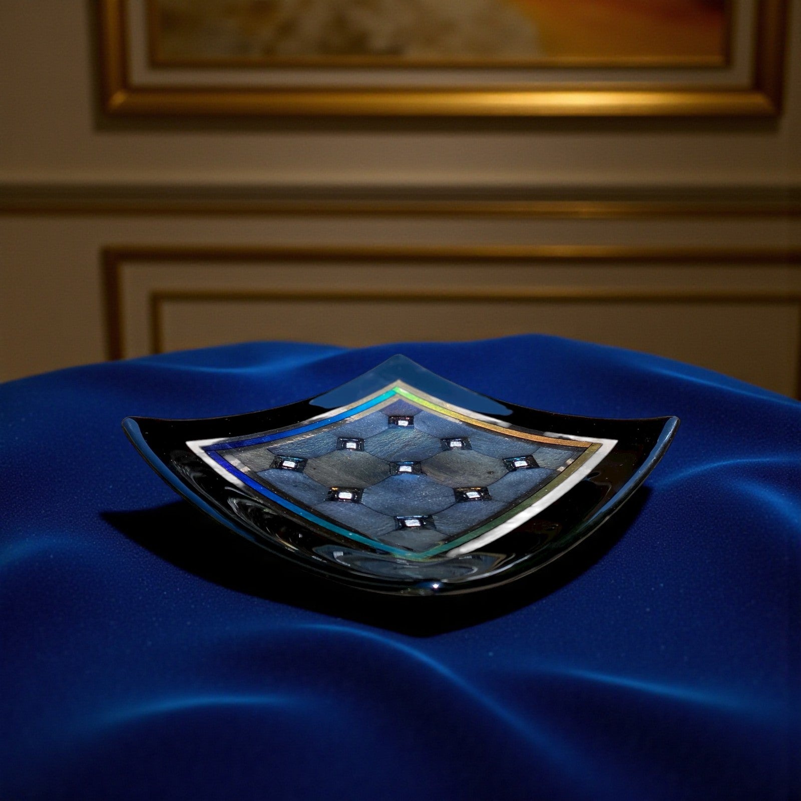 Close-up of a blue car emblem with a checkered pattern on a blurred background