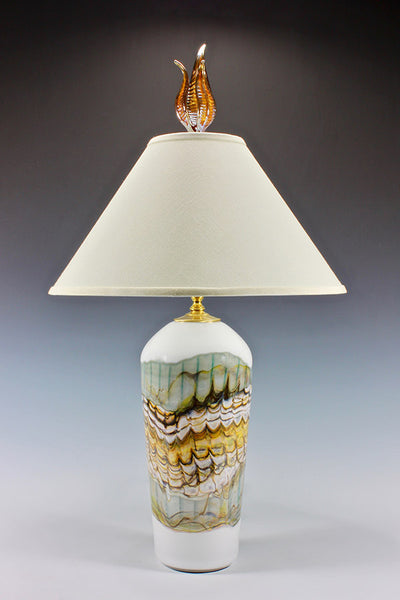 Decorative lamp with a textured base and white shade on a gradient background